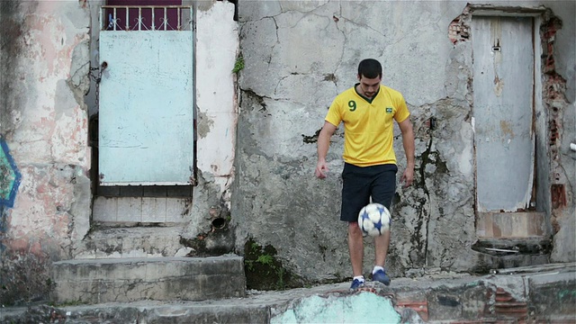 一个年轻人在巴西的贫民窟练习他的足球技巧视频下载