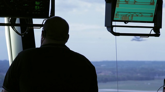 空中交通管制员望着杜勒斯机场空中交通管制塔窗外的照片，美国宇航局航天飞机承运人飞机/弗吉尼亚州斯特林视频下载