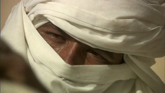 特写泛右架焦点-在突尼斯，一名戴头巾的男子正在拉紧绳子。/突尼斯视频下载