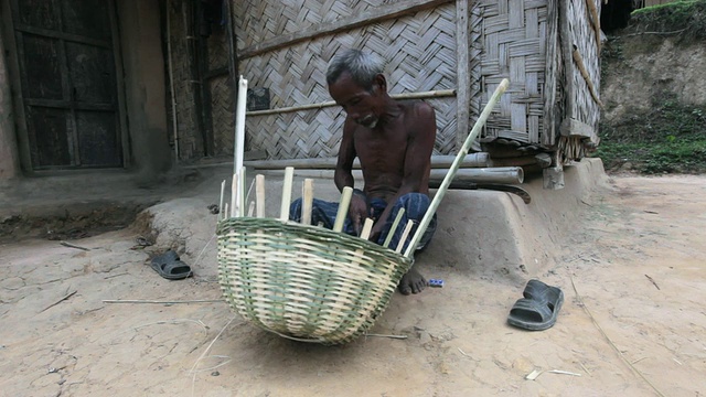 孟加拉国，印度次大陆，亚洲。来自加罗部落的男子正在编织传统的丛林篮子，加罗部落，Sreemangal (Srimangal)， Sylhet地区视频下载