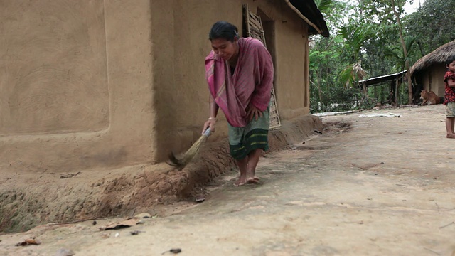 一名妇女在她的房子里扫地，孩子们在周围玩耍，离Sreemangal (Srimangal)不远，孟加拉国，印度次大陆，亚洲视频下载