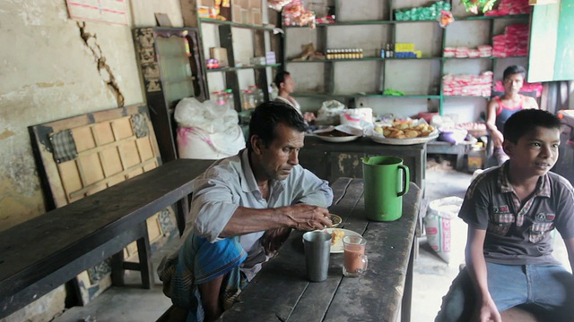 一名孟加拉国男子正在当地的一家餐馆里吃早餐和喝茶视频下载