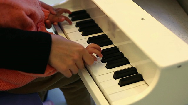 CU母亲教女儿弹钢琴的镜头/西安，中国视频素材