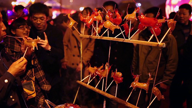 中国西安春节期间，在公园里制作糖人偶的小贩的MS照片视频下载
