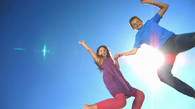 HD超级慢动作:快乐的兄弟姐妹在空中跳跃视频素材