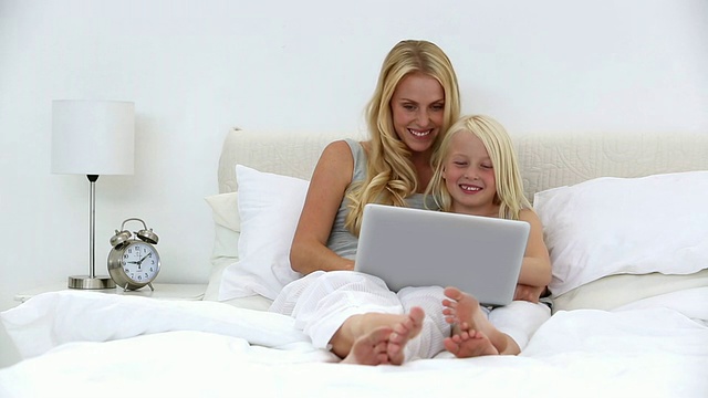 母亲和女儿一起使用笔记本电脑视频素材