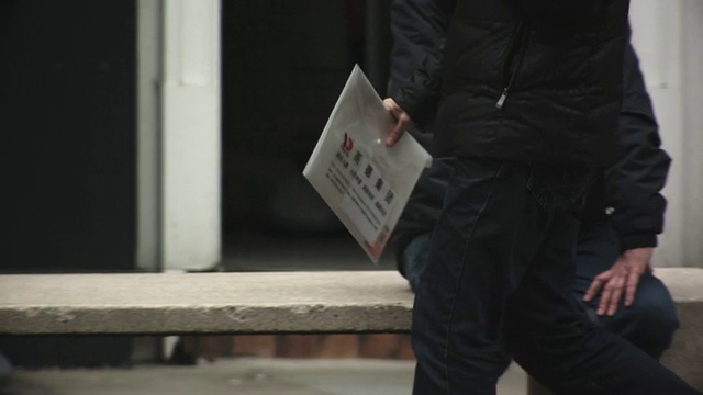 MS TS SLO MO男子带着文件夹走过街道/英国的照片视频下载