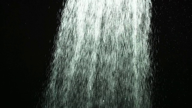 CU SLO MO拍摄的宽阔的水花通过框架在黑色背景/英国视频素材
