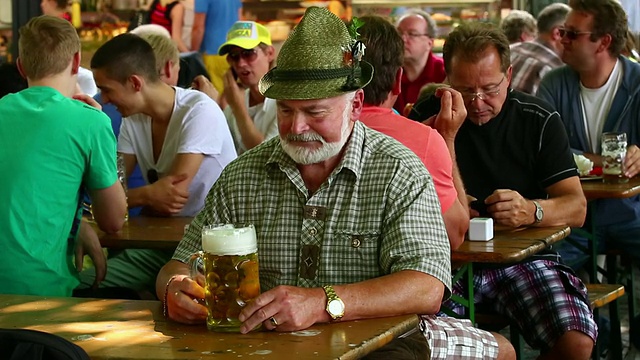 一名巴伐利亚男子在啤酒花园里享用啤酒视频素材