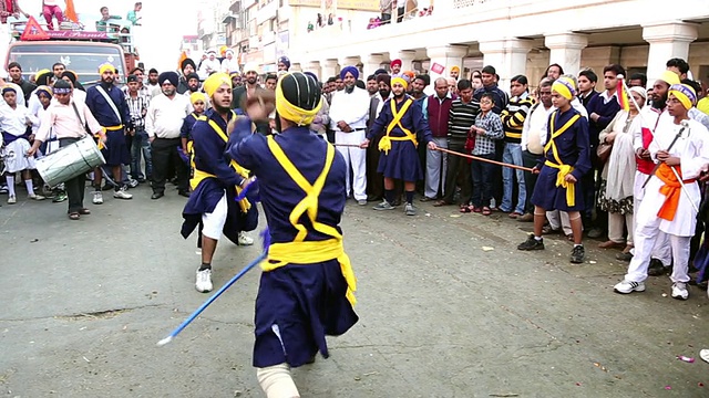 印度德里Nagar Kirtan游行中，两名男子在表演剑斗视频下载