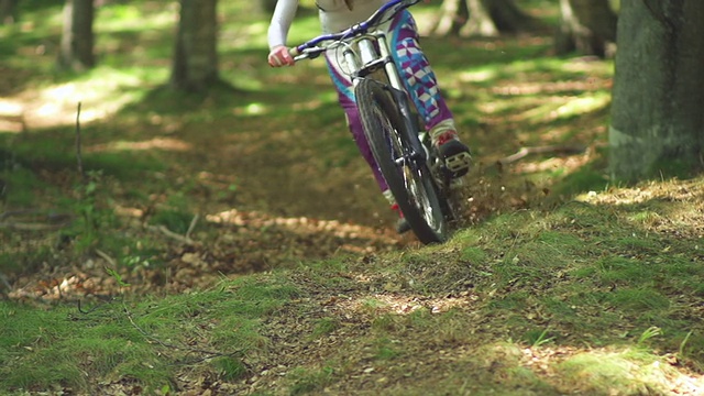 年轻女子骑山地自行车穿过一片森林视频素材