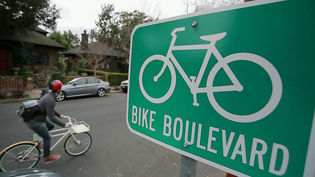 MS SLO MO在美国密歇根州底特律郊区的街道上拍摄的两名男子骑自行车的自行车标志视频下载