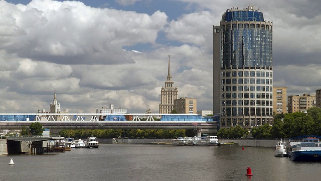 在俄罗斯莫斯科，可以看到斯大林时代的小型船只和现代化的桥梁和高楼大厦视频下载