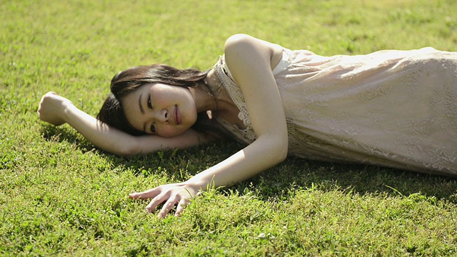 MS Shot of Woman躺在公园草坪上放松/宇次，京都，日本视频下载