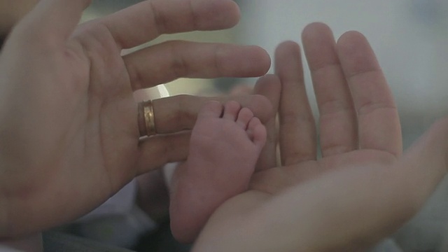 C/U婴儿脚和男人的手视频素材