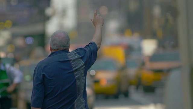 一个男人伸出手去叫出租车。车辆经过视频素材