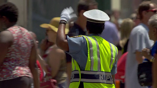 在纽约市一个炎热的夏天，一名NYDP警察指挥交通。视频下载