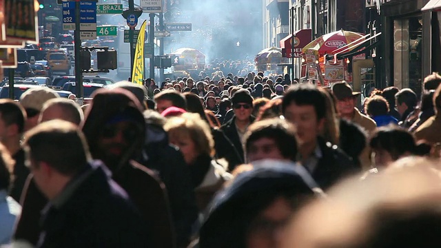 在圣诞节期间，人们走在第五大道拥挤的人行道上，街道上的小贩喷出的烟雾包围着交通拥堵的人们/纽约，美国视频下载