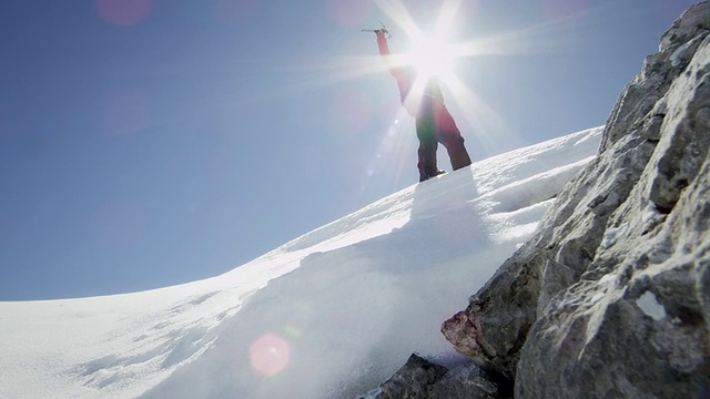 登山者在白雪覆盖的山峰上欢呼视频素材