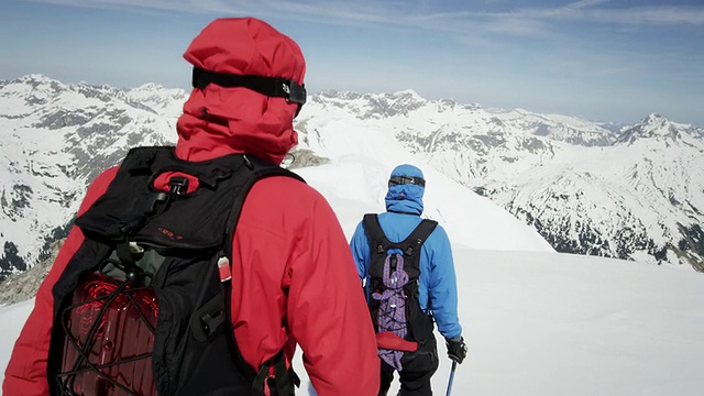 登山者行走在白雪覆盖的山顶上视频素材
