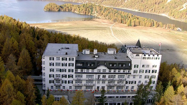 上图为Sils maria和瓦尔德豪斯酒店拍摄的Sils maria，在Sils湖的秋天被黄色的树包围着/ Sils maria，上恩加丁，瑞士视频素材