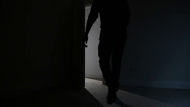 男人离开黑暗房间的剪影。视频素材