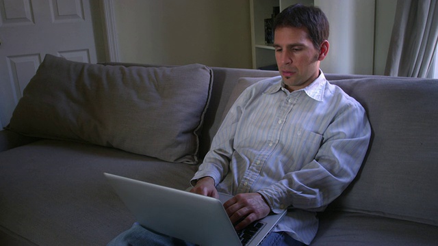 美国纽约，一名闷闷不乐的男子在公寓里用笔记本电脑打字，然后出现故障视频素材