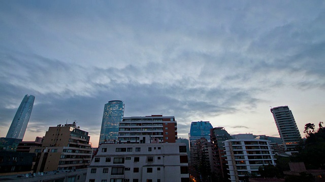 在智利圣地亚哥，多云的日落在El Golf社区的建筑上视频素材