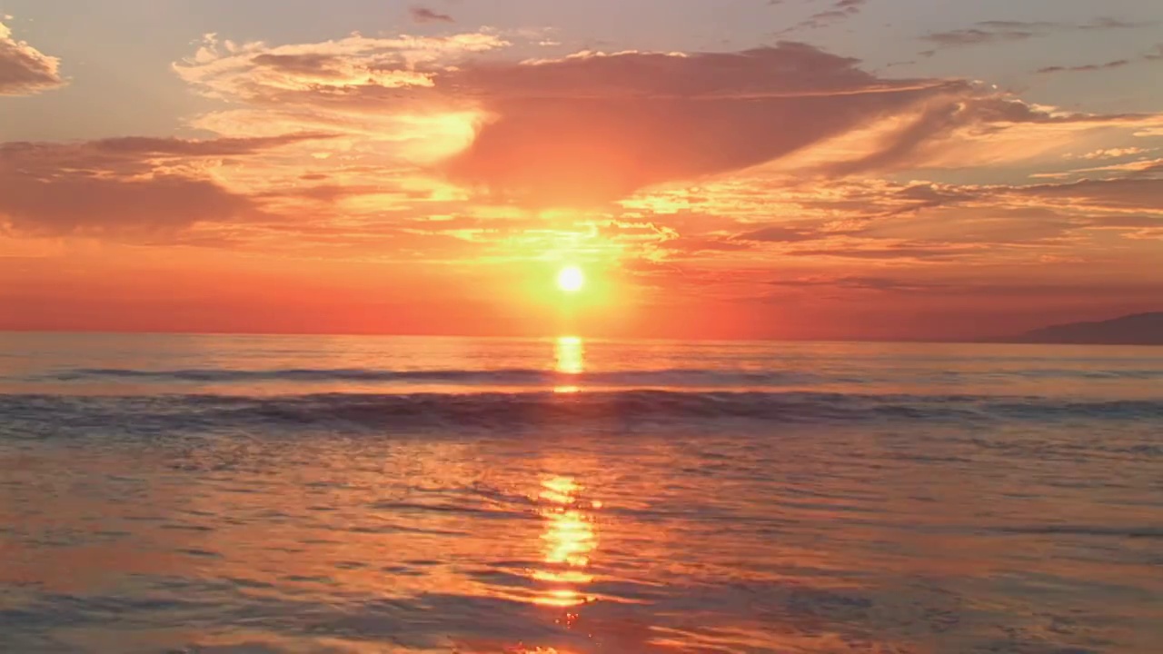 一个金色的田园般的加利福尼亚日落，当太阳落进温和的海浪的水域视频下载
