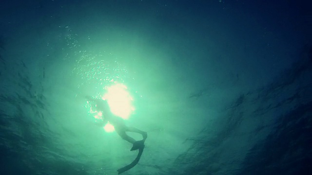 自由潜水员从深渊中浮出水面视频素材