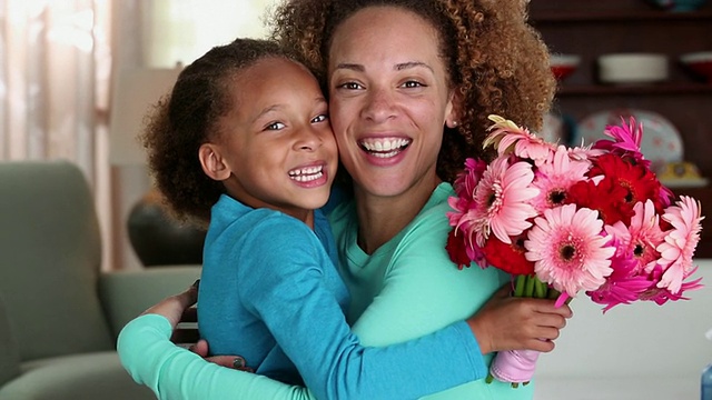 美国弗吉尼亚州里士满，年轻的女儿给母亲一束花，对着照相机微笑视频下载
