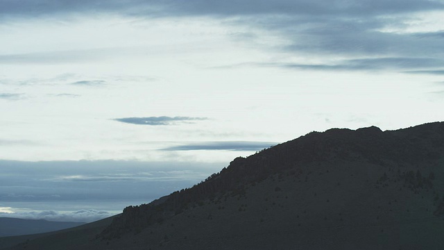 在黄昏魔法时刻，云在俄勒冈中部的高沙漠山上移动的WS视图/ Bend，俄勒冈，美国视频下载