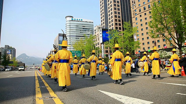 韩国首尔，传统的韩国服饰游行队伍抬着轿子穿过市政厅广场视频下载