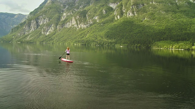 女人站起来划桨冲浪视频素材