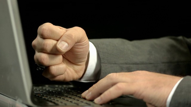 高清超级慢动作:商人用拳头打笔记本电脑视频素材