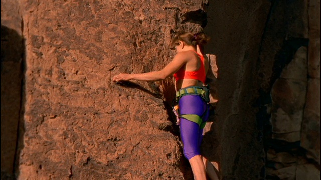 女人攀爬岩石视频素材