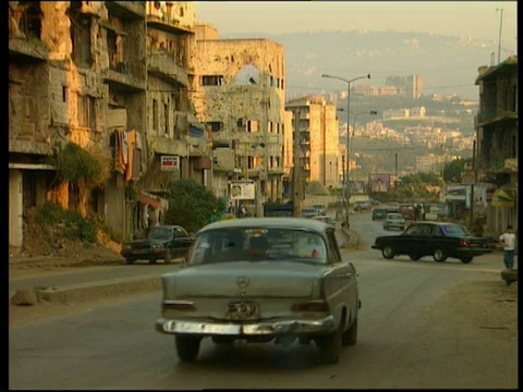 贝鲁特市内街道上破败的公寓街区，汽车不断驶过视频素材