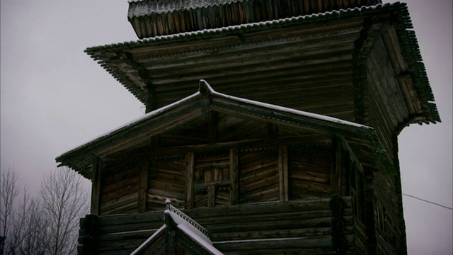 俄罗斯一座木质教堂的积雪屋顶上有洋葱圆屋顶。高清。视频素材