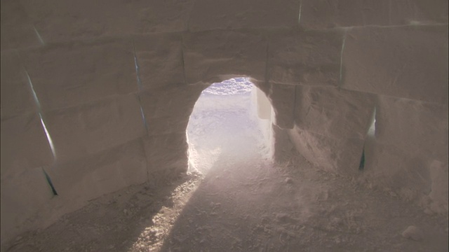 阳光透过圆顶冰屋的拱形入口照射进来。高清。视频素材