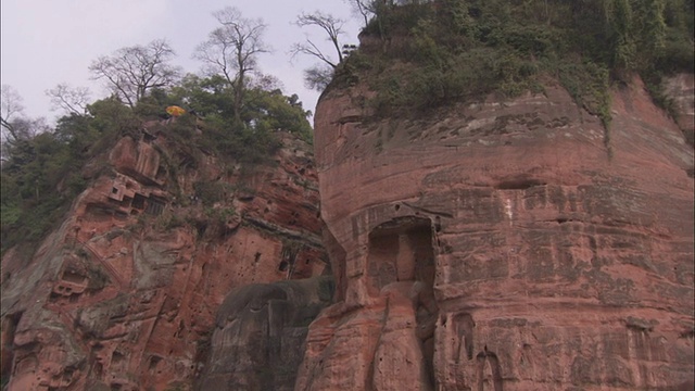 从底部可以看到一尊雕刻在悬崖上的佛像。高清。视频下载