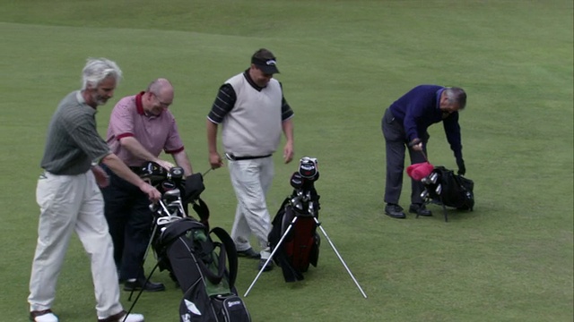 在苏格兰法夫的一个高尔夫球场上，高尔夫球手们把球杆放回自己的包里。高清。视频下载