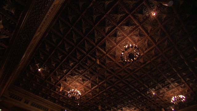 在装饰艺术电影院图廷(Tooting)的豪华礼堂里，吊灯悬挂在镶金的天花板上。高清。视频下载