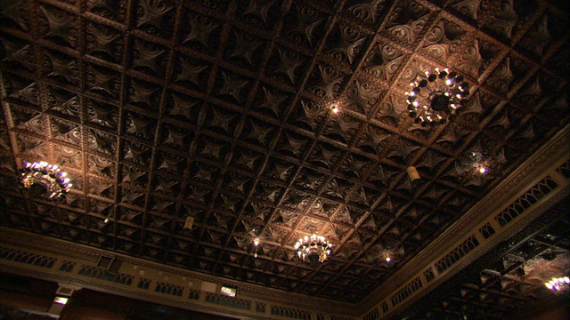 图廷(Tooting)一家装饰艺术电影院的天花板上悬挂着枝形吊灯，上面覆盖着雕刻精美的瓷砖。高清。视频下载