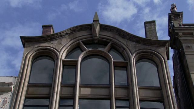 漂浮的云朵反射在利物浦库克街16号的窗户上。高清。视频下载