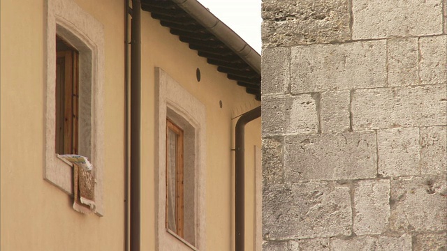 在意大利的蒙特普恰诺(Montepulciano)，一幢石头建筑对面的窗户上挂着洗好的衣服。高清。视频素材