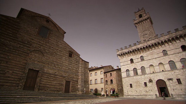 阴沉沉的天空隐现在意大利蒙特普尔西亚诺大教堂和市政厅后面。高清。视频素材