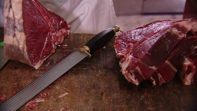 在意大利的一家商店里，屠夫指着一块切好的肉。高清。视频素材