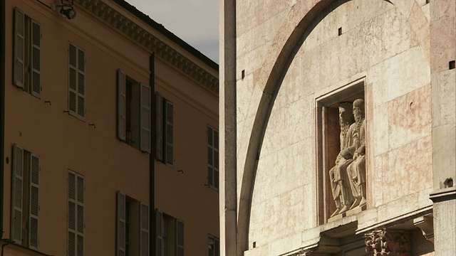 帕尔马大教堂外墙上的石拱下矗立着一尊雕像。高清。视频下载