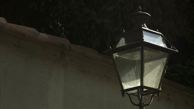 一盏街灯悬挂在意大利帕尔马的一堵石墙上。高清。视频下载
