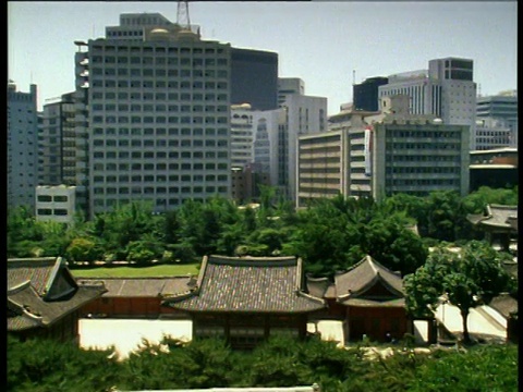 潘文石穿过首尔德sugung宫，后面是摩天大楼的办公室。视频素材